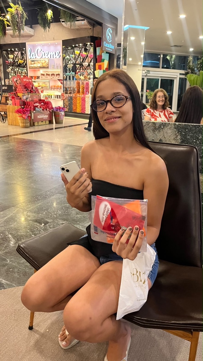 Cliente com iPhone e embalagem da Importadora Mineira