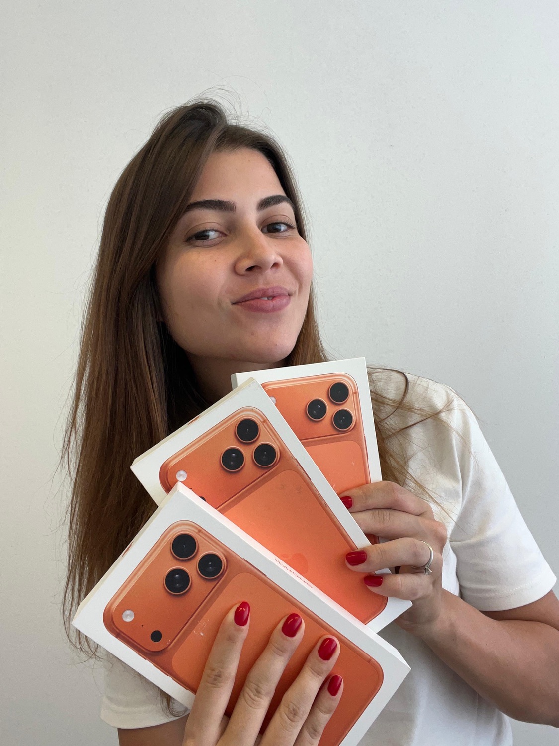 Cliente segurando caixas de iPhone compradas com a Importadora Mineira
